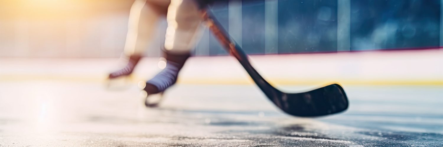 close-up of hockey skates and hockey stick on rink