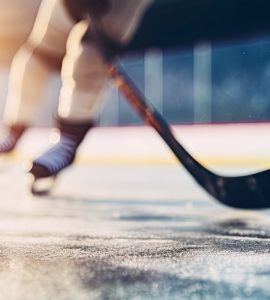 close-up of hockey skates and hockey stick on rink