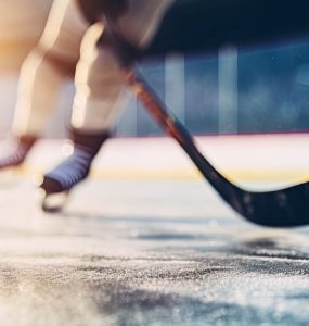 close-up of hockey skates and hockey stick on rink