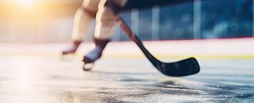 close-up of hockey skates and hockey stick on rink