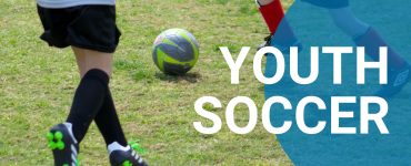 two children, view of legs playing outdoor soccer